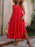 Woman wearing a red dress with a straw bag outdoors.